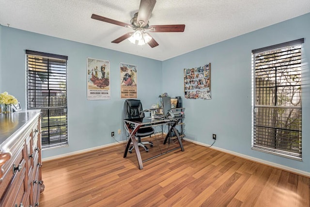 home office featuring a textured ceiling, light hardwood / wood-style floors, and ceiling fan