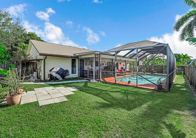 rear view of property featuring a fenced in pool, a patio, a yard, and glass enclosure