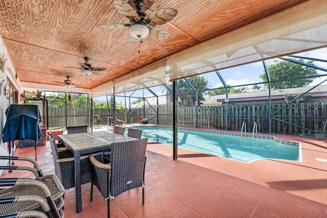 view of swimming pool with ceiling fan, a lanai, and a patio