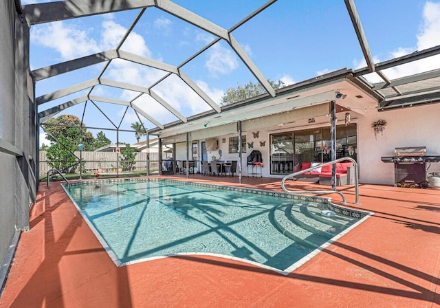 view of swimming pool with grilling area, a patio area, and glass enclosure