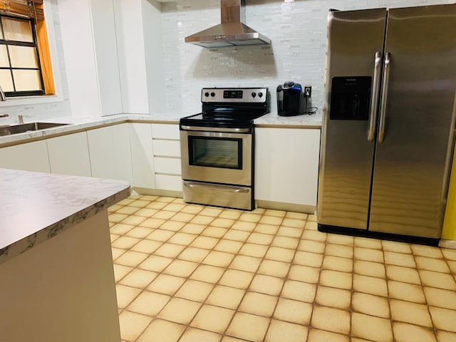 kitchen with white cabinets, wall chimney range hood, stainless steel appliances, sink, and backsplash