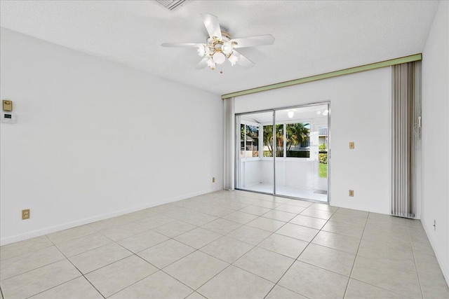 tiled empty room with ceiling fan and a textured ceiling