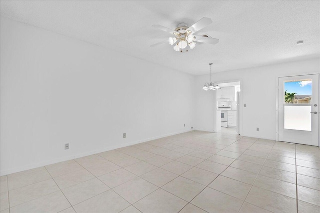 tiled empty room with a textured ceiling and ceiling fan with notable chandelier