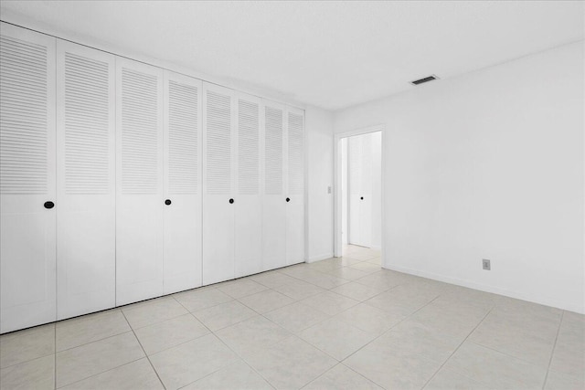 unfurnished bedroom featuring a closet and light tile patterned flooring