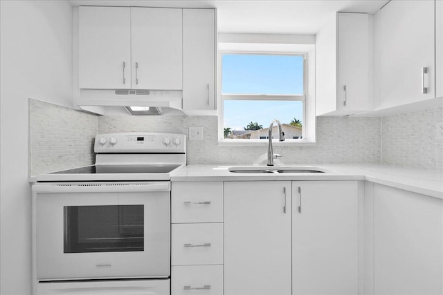 kitchen featuring sink, white cabinetry, white electric range, and tasteful backsplash