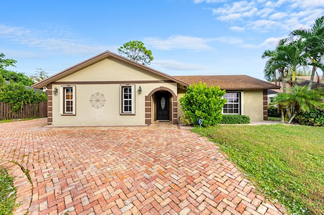 ranch-style home featuring a front lawn