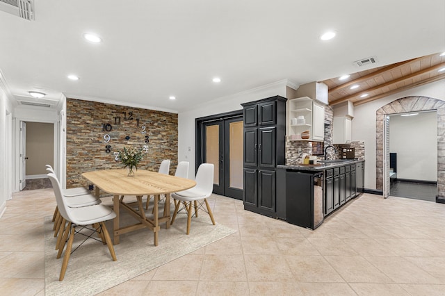 kitchen featuring black dishwasher, sink, backsplash, ornamental molding, and light tile patterned floors