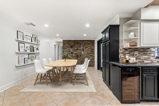 tiled dining space featuring wine cooler, bar, and crown molding