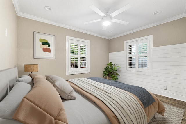 bedroom featuring hardwood / wood-style flooring, ceiling fan, and ornamental molding