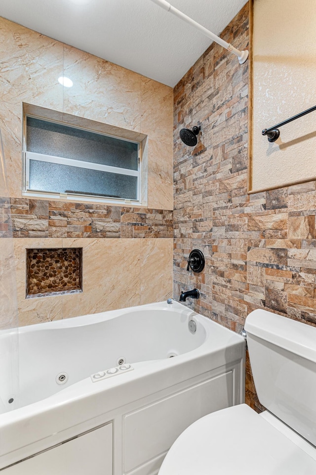 bathroom with toilet, tiled shower / bath combo, and a textured ceiling