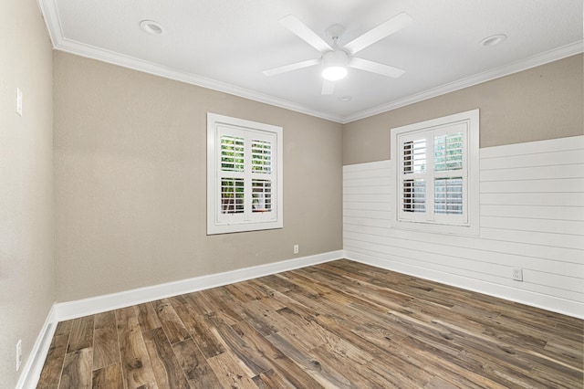 empty room featuring wooden walls, ceiling fan, ornamental molding, and dark hardwood / wood-style flooring