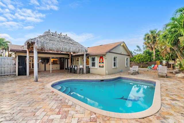 view of pool with an outdoor kitchen, an outdoor bar, and a patio area