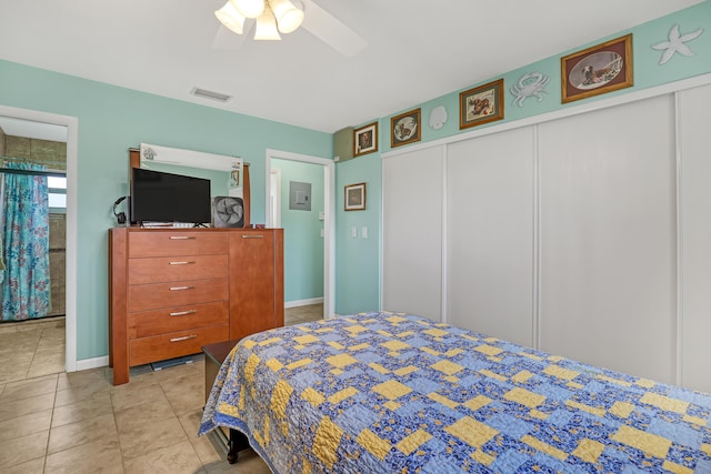 bedroom with a closet, light tile patterned floors, and ceiling fan