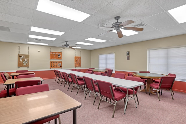 carpeted dining area featuring ceiling fan and a paneled ceiling