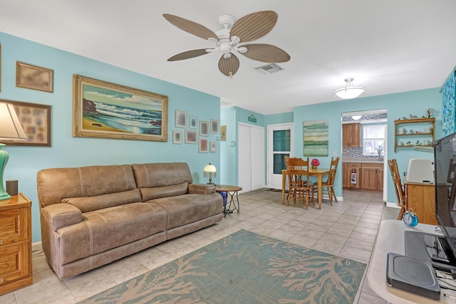 tiled living room featuring ceiling fan