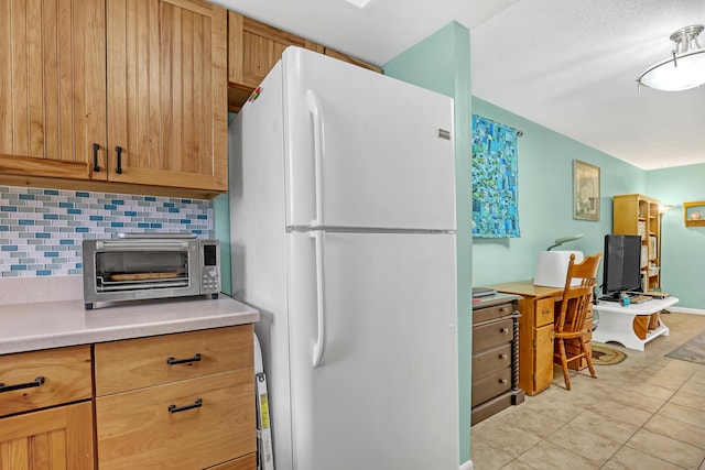 kitchen featuring backsplash and white refrigerator