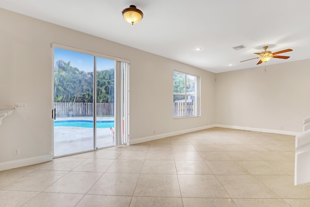 tiled spare room with ceiling fan