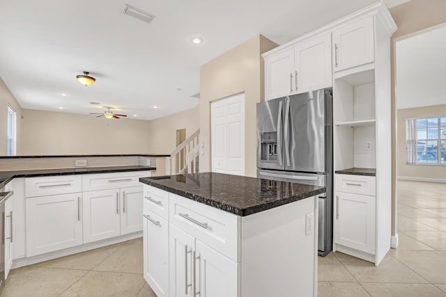 kitchen featuring a kitchen island, light tile patterned flooring, white cabinets, and stainless steel fridge with ice dispenser