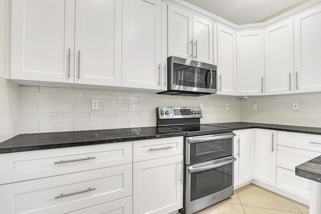 kitchen with backsplash, white cabinetry, stainless steel appliances, and light tile patterned flooring