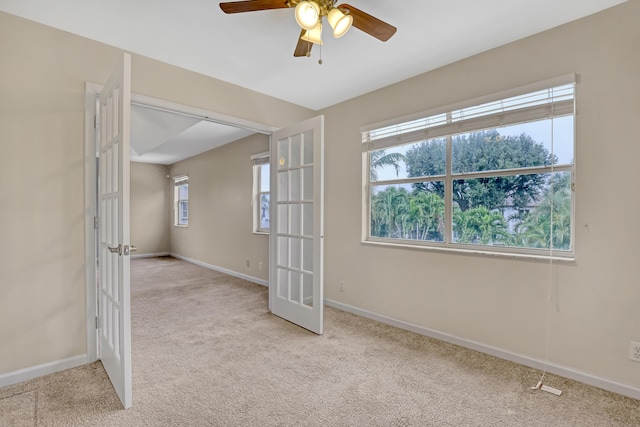 unfurnished room featuring light carpet, ceiling fan, and french doors