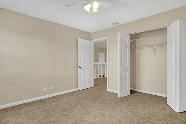 unfurnished bedroom with ceiling fan, a closet, and carpet floors