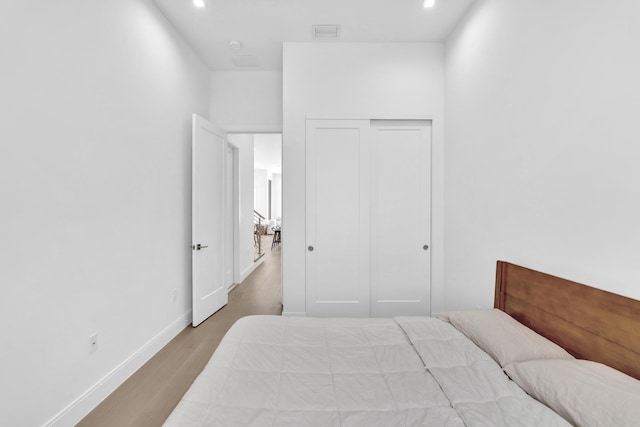 bedroom with light wood-type flooring and a closet