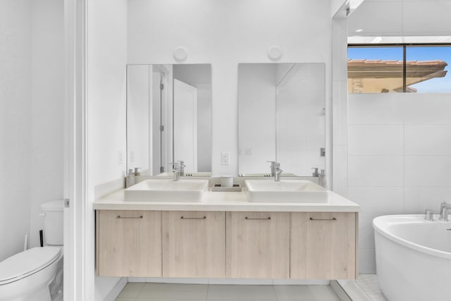 bathroom featuring toilet, a bathtub, tile walls, tile patterned flooring, and vanity