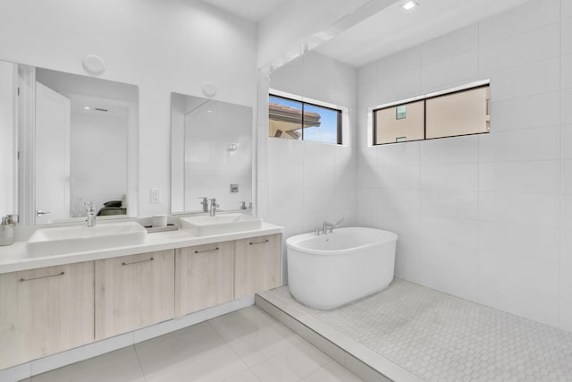 bathroom featuring vanity, a bathing tub, tile walls, and tile patterned flooring