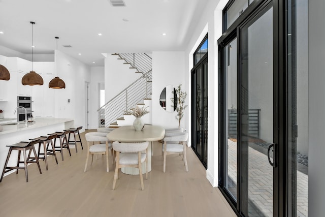 dining space with sink and light hardwood / wood-style floors