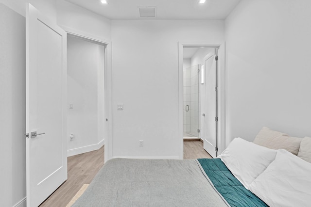 bedroom with light hardwood / wood-style floors and connected bathroom