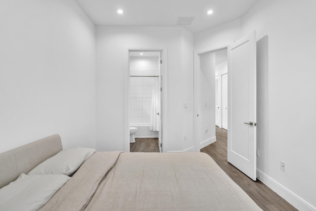 bedroom featuring dark wood-type flooring and connected bathroom