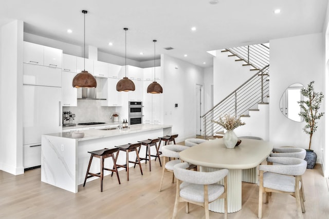 dining space with light hardwood / wood-style floors and sink