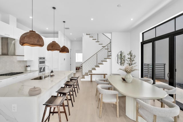 dining space with sink and light hardwood / wood-style flooring