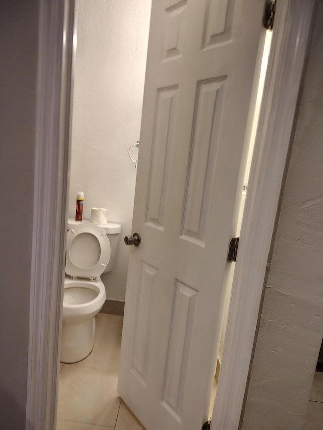 bathroom with toilet and tile patterned floors