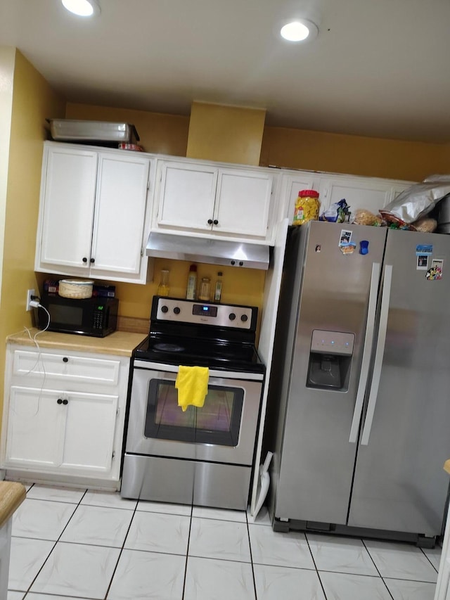 kitchen with light tile patterned floors, white cabinetry, and appliances with stainless steel finishes