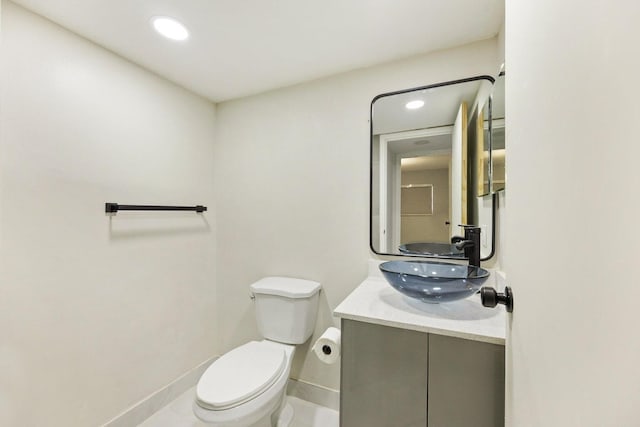 bathroom featuring toilet, recessed lighting, baseboards, and vanity