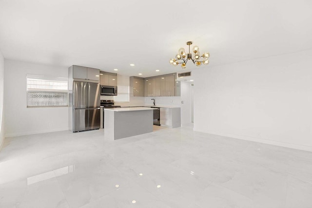 kitchen featuring modern cabinets, a center island, decorative light fixtures, stainless steel appliances, and light countertops