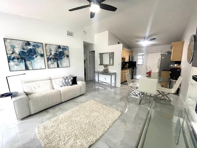 living room featuring lofted ceiling and ceiling fan