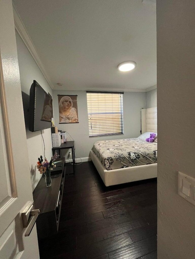 bedroom featuring crown molding and dark hardwood / wood-style floors