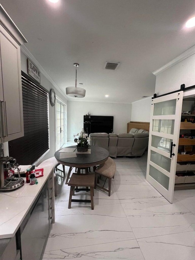 dining area with a barn door and ornamental molding