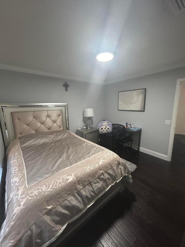 bedroom featuring dark hardwood / wood-style floors and ornamental molding