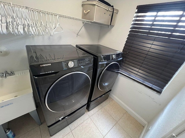 laundry room featuring washer and clothes dryer and tile patterned floors