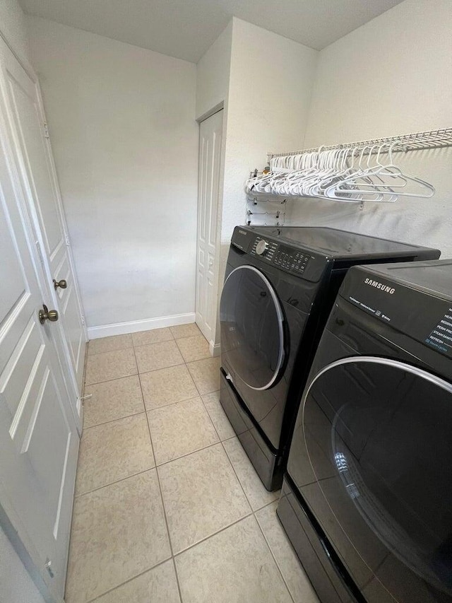 laundry room featuring separate washer and dryer and light tile patterned flooring