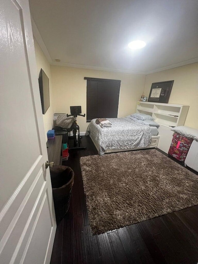 bedroom featuring dark hardwood / wood-style floors and ornamental molding