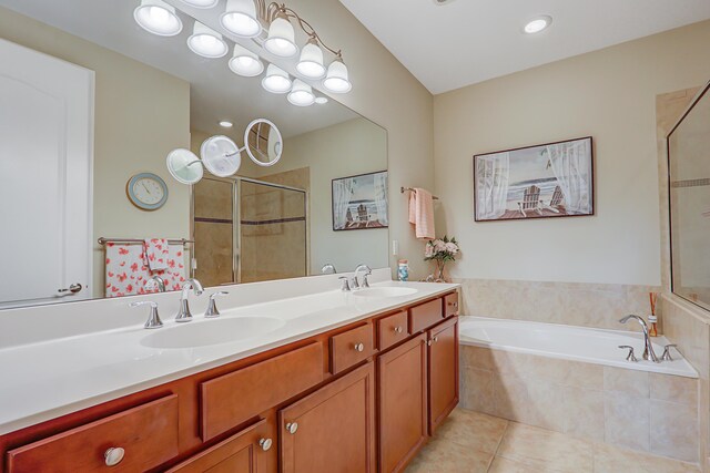 bathroom featuring a garden tub, a stall shower, a sink, and tile patterned floors