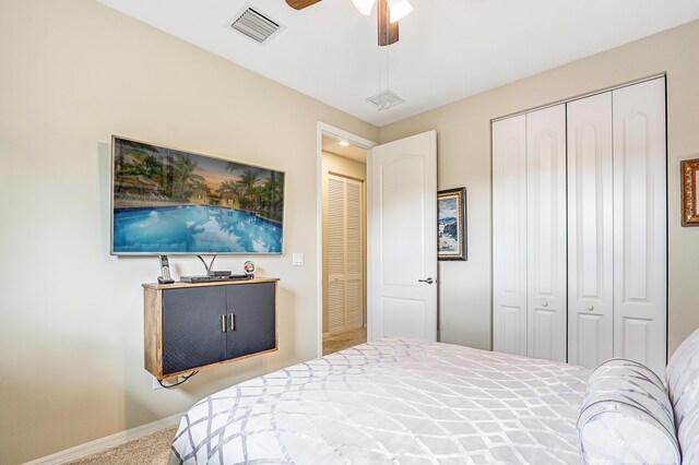 bedroom with baseboards, visible vents, ceiling fan, carpet, and a closet