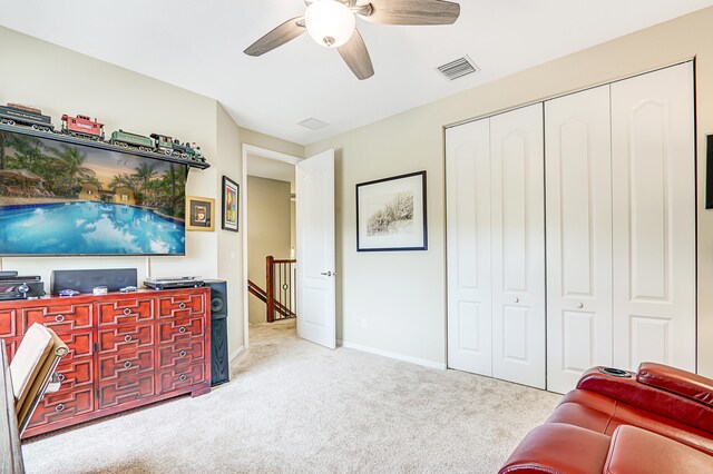 living area featuring ceiling fan, visible vents, baseboards, and light colored carpet