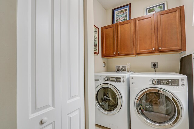 laundry area with cabinet space and separate washer and dryer