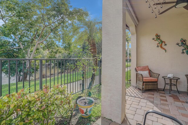 view of patio featuring ceiling fan and fence