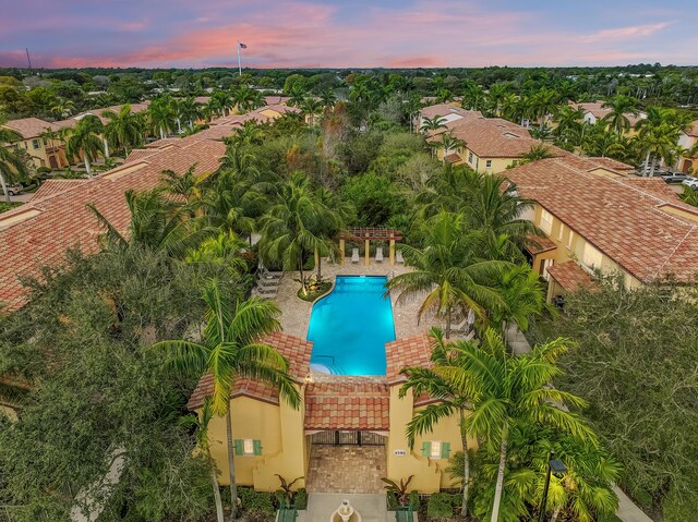 pool at dusk with a patio and a community pool